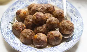 Polpette dorate e succulente, cotte alla perfezione in friggitrice ad aria, servite su un piatto decorato.