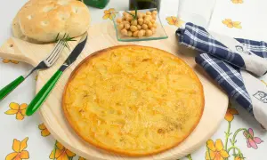 Farinata di ceci in padella, dorata e profumata, pronta per essere gustata con pane fresco e un rametto di rosmarino.
