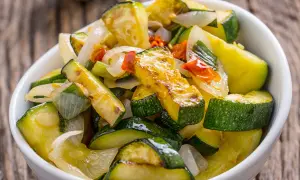 Zucchine in padella, dorate e saporite, con cipolla e pomodoro. Un contorno leggero e gustoso, pronto da gustare.