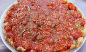 Tarte tatin di pomodorini confit, con cipolle caramellate e erbe aromatiche, un tripudio di sapori mediterranei.