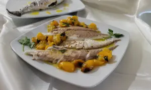 Orata in friggitrice ad aria, servita con pomodorini gialli e prezzemolo. Un piatto leggero e gustoso.