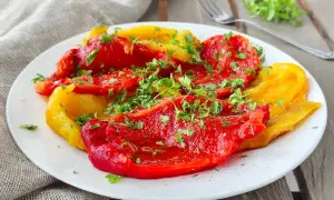 Peperoni rossi e gialli cotti in friggitrice ad aria, conditi con prezzemolo fresco. Un contorno saporito e leggero.