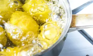 Patate senza buccia che bollono in una pentola. Il tempo di cottura patate lesse senza buccia è quasi terminato, le bollicine indicano che sono pronte.