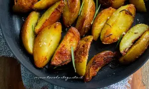 Patate in padella croccanti, dorate e profumate al rosmarino, pronte per essere gustate.