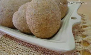 Panini integrali fatti in casa, morbidi e fragranti, serviti su un piatto bianco.