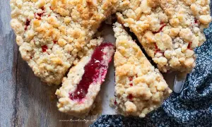 Una deliziosa sbriciolata alla marmellata, con la sua crosta dorata e il ripieno rosso brillante, pronta per essere gustata.