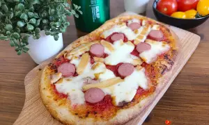 Deliziose pizzette fatte in casa con wurstel e formaggio filante, pronte per essere gustate.