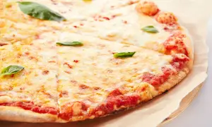 Pizza margherita con lievito istantaneo, croccante e dorata, con abbondante mozzarella filante e basilico fresco.