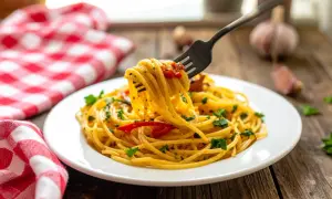 Un piatto di spaghetti alla carrettiera fumante, conditi con pomodoro e prezzemolo, pronti per essere gustati.