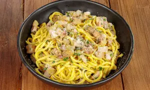 Spaghetti alla chitarra conditi con guanciale croccante, pecorino e prezzemolo fresco, un piatto che sa di tradizione.