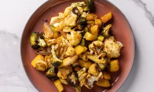 Un piatto di verdure miste, tra cui broccoli, cavolfiore e patate, cotte in friggitrice ad aria, con un aspetto dorato e appetitoso.