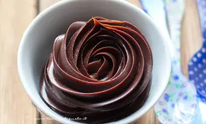 Una spirale perfetta di ganache al cioccolato in una ciotola bianca, pronta per essere gustata.