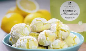 Biscotti con farina di mandorle, morbidi e profumati, pronti per essere gustati con limoni freschi sullo sfondo.