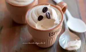 Deliziosa crema al caffè servita in tazzine, guarnita con chicchi di caffè. Perfetta per una pausa golosa.