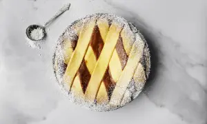 Pastiera napoletana pronta, cosparsa di zucchero a velo. Un assaggio di come si fa la pastiera, con la sua crostata decorata a rombi.