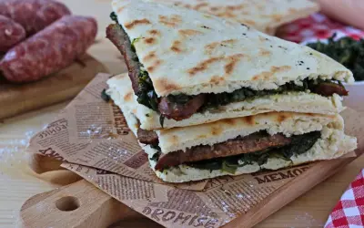 Torta al testo ripiena di salsiccia e verdure, un classico umbro pronto da gustare.