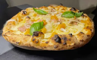 Pizza tonno e cipolla con mozzarella filante, pomodorini e basilico fresco. Croccante e saporita, un classico intramontabile.