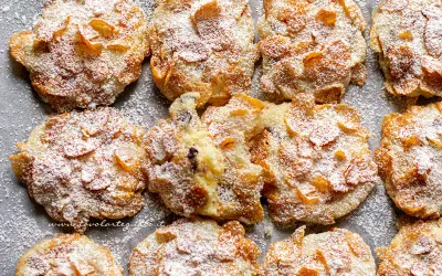 Biscotti croccanti, simili a rose del deserto, ricoperti di zucchero a velo e fiocchi di mais.