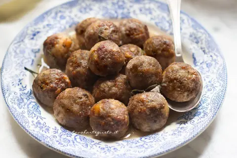 Polpette dorate e succulente, cotte alla perfezione in friggitrice ad aria, servite su un piatto decorato.