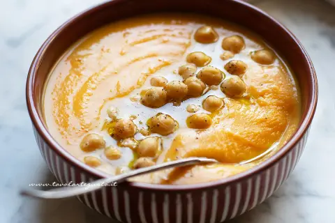 Un cremoso passato di verdure arancione, guarnito con ceci e un filo d'olio. Perfetto per una cena confortante.