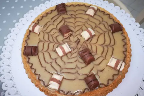 Torta Kinder Bueno con decorazione a ragnatela e pezzi di cioccolato.