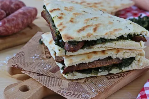 Torta al testo ripiena di salsiccia e verdure, un classico umbro pronto da gustare.