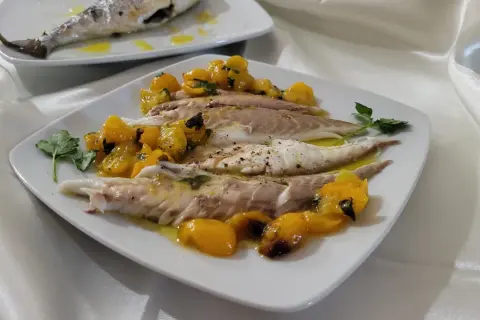 Orata in friggitrice ad aria, servita con pomodorini gialli e prezzemolo. Un piatto leggero e gustoso.