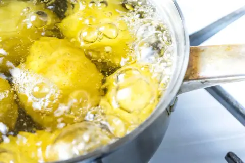 Patate senza buccia che bollono in una pentola. Il tempo di cottura patate lesse senza buccia è quasi terminato, le bollicine indicano che sono pronte.