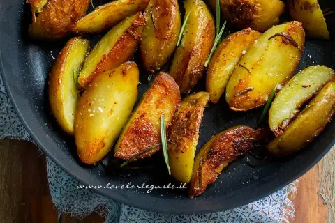 Patate in padella croccanti, dorate e profumate al rosmarino, pronte per essere gustate.