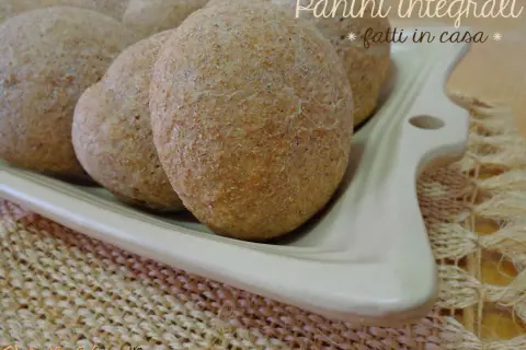 Panini integrali fatti in casa, morbidi e fragranti, serviti su un piatto bianco.
