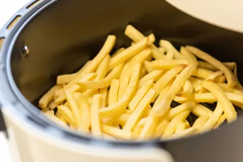 Patate dorate e croccanti pronte per essere gustate, appena uscite dalla friggitrice ad aria.