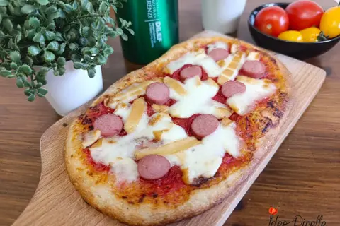 Deliziose pizzette fatte in casa con wurstel e formaggio filante, pronte per essere gustate.