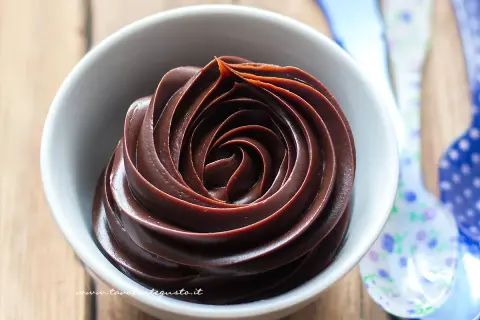 Una spirale perfetta di ganache al cioccolato in una ciotola bianca, pronta per essere gustata.