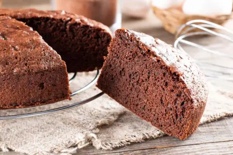 Una fetta di torta alla Nutella soffice e golosa, appena sfornata, su una griglia di raffreddamento.