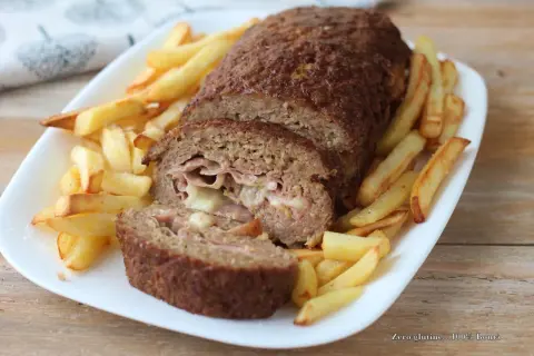 Polpettone ripieno di prosciutto e formaggio, cotto in friggitrice ad aria, servito con patatine fritte croccanti.