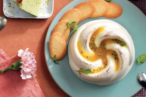 Deliziosa crema al latte con frutto della passione e biscotti croccanti, guarnita con menta fresca.