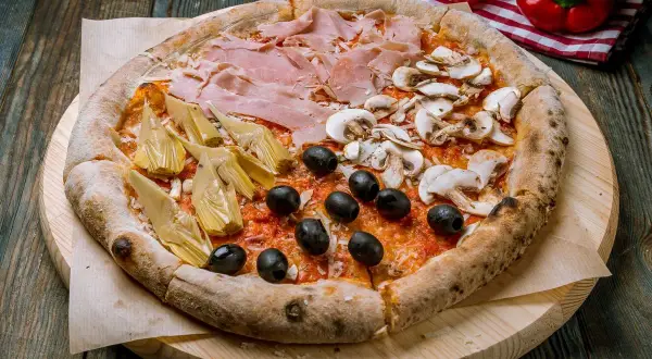 Pizza 4 stagioni con prosciutto, funghi, carciofi e olive nere, un tripudio di sapori che celebra ogni stagione.