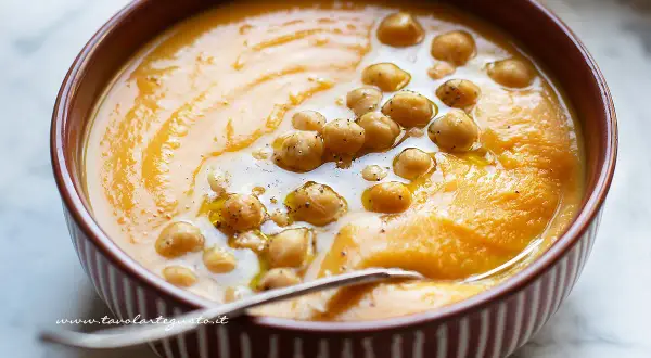 Un cremoso passato di verdure arancione, guarnito con ceci e un filo d'olio. Perfetto per una cena confortante.