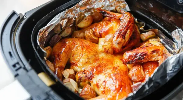 Pollo dorato e patate croccanti in friggitrice ad aria, un pasto delizioso e veloce.