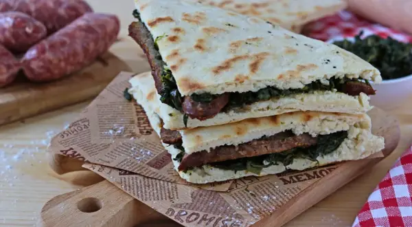 Torta al testo ripiena di salsiccia e verdure, un classico umbro pronto da gustare.