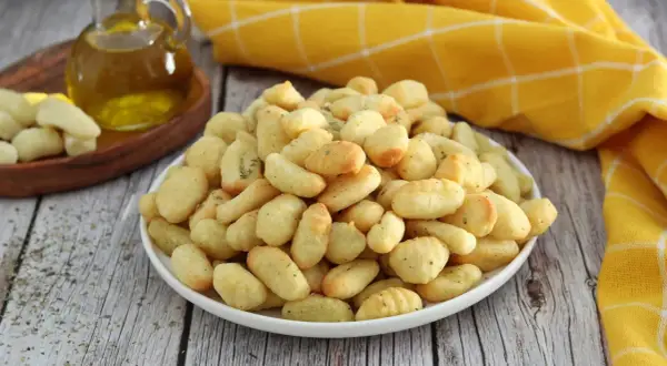 Gnocchi dorati e croccanti, preparati in friggitrice ad aria, conditi con erbe aromatiche.