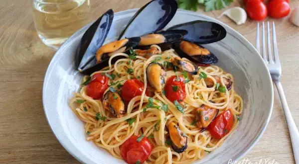 Spaghetti con le cozze e pomodorini, un piatto di mare profumato e colorato, pronto per essere gustato con un bicchiere di vino bianco.