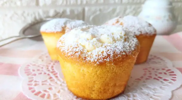 Muffin dorati spolverati di zucchero a velo, perfetti per una ricetta muffin semplici e golosa.