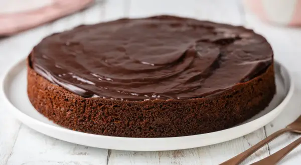 Una deliziosa torta al cioccolato morbida, ricoperta da una glassa lucida e invitante, pronta per essere gustata.