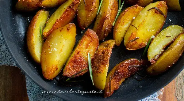 Patate in padella croccanti, dorate e profumate al rosmarino, pronte per essere gustate.