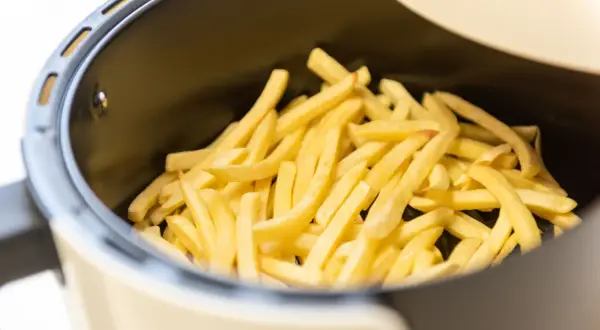 Patate dorate e croccanti pronte per essere gustate, appena uscite dalla friggitrice ad aria.