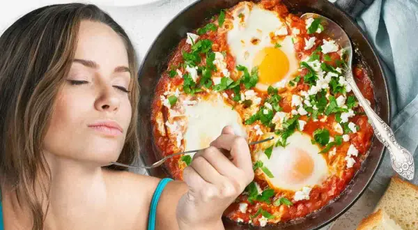 Donna assapora deliziosi uova al pomodoro con formaggio e prezzemolo, servite in padella con pane tostato.