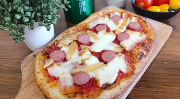 Deliziose pizzette fatte in casa con wurstel e formaggio filante, pronte per essere gustate.