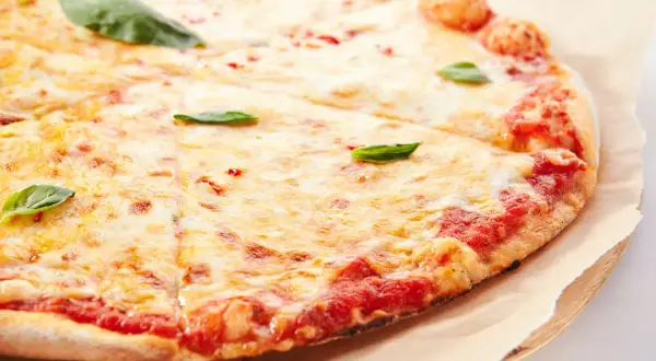 Pizza margherita con lievito istantaneo, croccante e dorata, con abbondante mozzarella filante e basilico fresco.