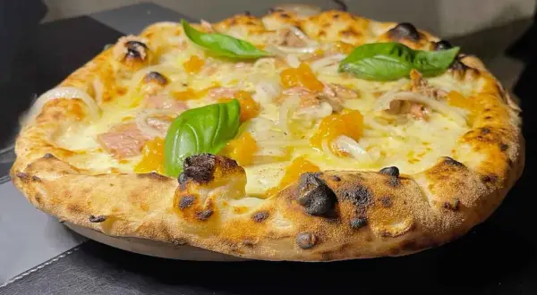 Pizza tonno e cipolla con mozzarella filante, pomodorini e basilico fresco. Croccante e saporita, un classico intramontabile.